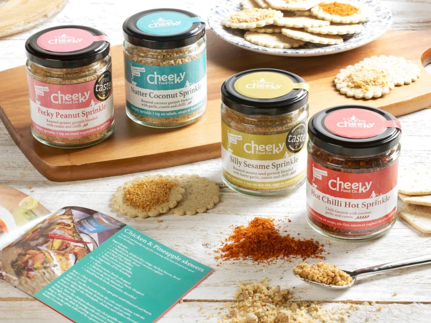 Four Cheeky Food Co seasoning jars, each flavour with its own colour-coded printed label